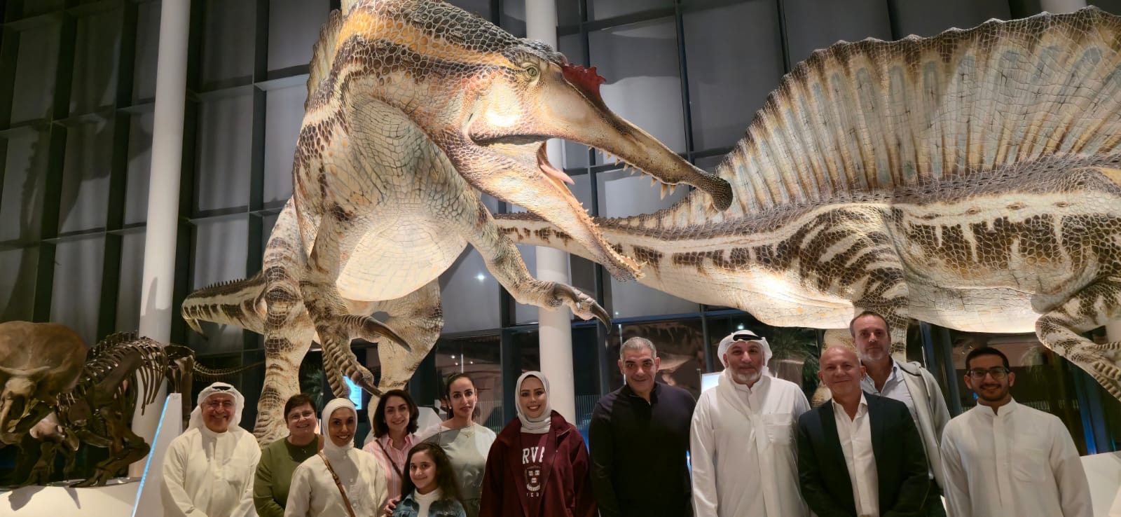 group posing in front of dinosaur
